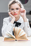 beautiful young girl in glasses with an interesting book posing