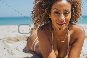 Pretty woman in bikini lying on beach