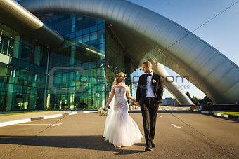 Bride and groom walking near the futuristic building