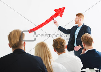 Businessman draws positive statistics of his company during a training meeting. Concept of success