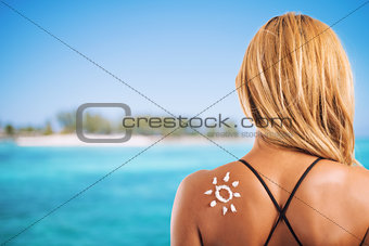 Girl in swimsuit with a sun made with sunscreen