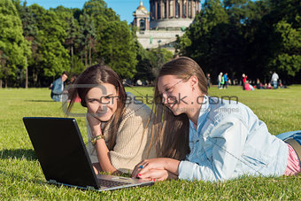 Two girls in the park with a laptop