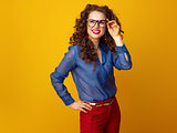 woman in glasses on yellow background looking at copy space