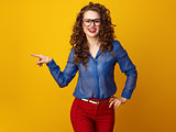 smiling stylish woman in glasses pointing at something