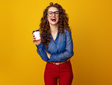 happy stylish woman on yellow background with coffee cup