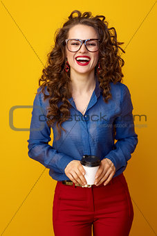 smiling modern woman with coffee cup isolated on yellow