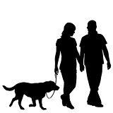 Silhouette of couple taking dog for walk