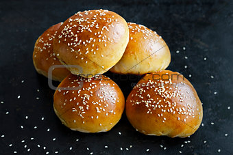 Buns with sesame seeds on a black background