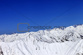 Winter snow mountains and blue clear sky