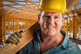 Smiling Contractor in Hard Hat Holding Plank of Wood At Construc