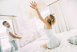Love happy couple in the bedroom with feathers