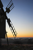 Old wooden windmill by sunset