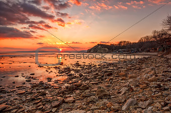 Exciting sunset/sunrise on the rocky coast with water reflection