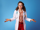 paediatrist doctor shrugging shoulders on blue