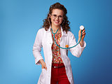 happy paediatrist woman using stethoscope on blue