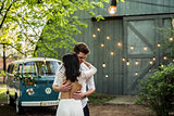 Merry happy young couple hugging near a retro bus