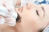 Cosmetic procedure. Microcurrent therapy for the face. Young gir