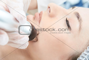 Cosmetic procedure. Microcurrent therapy for the face. Young gir