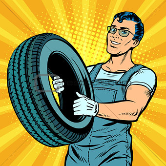 Male car mechanic with wheel