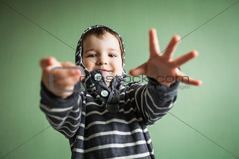 joyful smiling boy posing with arms stretched out in welcome gesture.