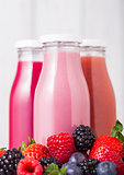 Glass bottles with fresh summer berries smoothie