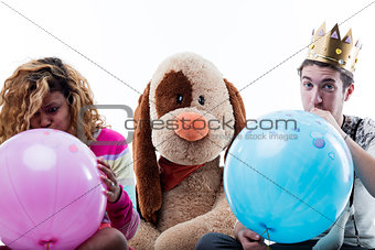 Young woman with man blowing big balloons