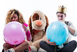 Young woman with man blowing big party balloons