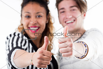Two young cheerful people giving thumbs up