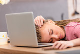 Tired young university student asleep on a laptop