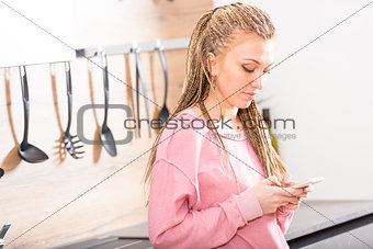 Trendy stylish young woman using her mobile
