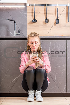 Serious trendy young woman using her mobile