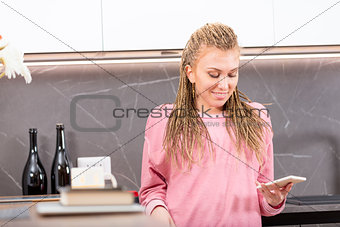 Happy relaxed young woman using her mobile