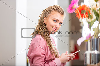 Smiling friendly young woman using a mobile
