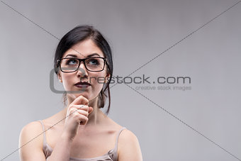Attractive woman in glasses deep in thought
