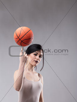 Attractive sporty woman balancing a basketball