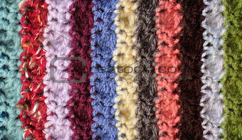 Crocheted yarn stitches in mixed colour stripes background