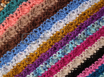 Diagonal stripes of crocheted stitches in multi-coloured wool ba