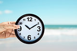 young man with a clock on the beach