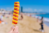 man eating a popsicle on the beach