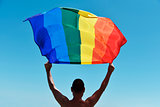 man with a rainbow flag over his head