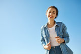 portrait of a young attractive woman on the blue sky background