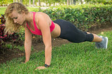 Blond girl, wears sportswear and exercises in the garden