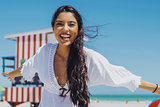 Cheerful ethnic woman laughing on beach