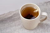 Cup of tea on table with sackcloth, top view, close-up, selective focus