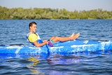 Young Happy Professional Kayaker Resting in Kayak on River under Bright Morning Sun. Sport and Active Lifestyle Concept