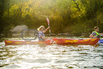 Young Happy Couple Paddling Kayaks on Beautiful River or Lake