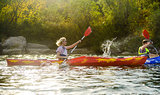 Young Happy Couple Paddling Kayaks on Beautiful River or Lake