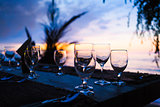 Glasses on table in tropical restaurant at sunset