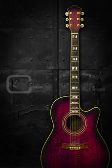 Purple acoustic guitar over dark background