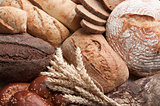 Different types of bread with ears of wheat.